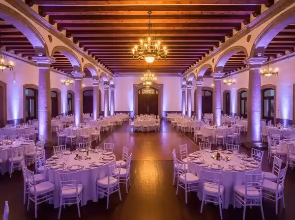Salón de boda con columnas en morado y vigas de madera dentro de un montaje mayor