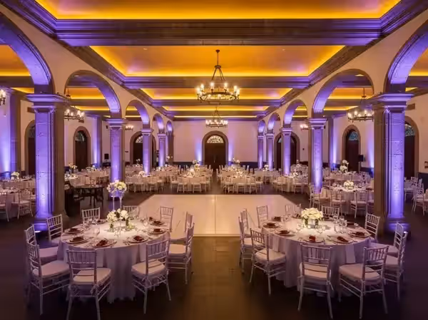 Arcos en violeta dentro de un salón de gala con candelabros