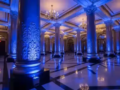 Columnas de un salón de gala encendidas en azul dentro de un venue grande