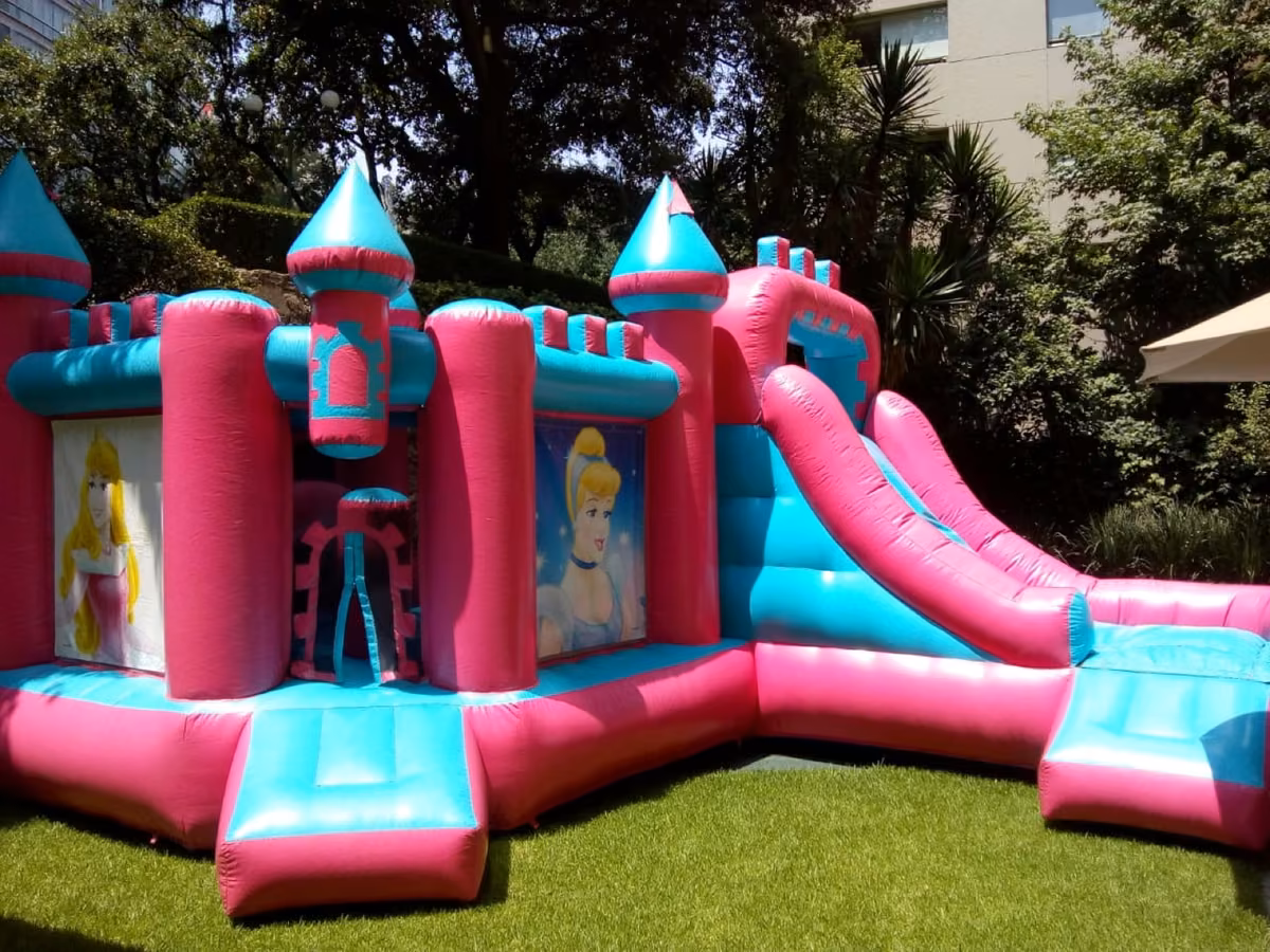 Castillo de Princesas inflable rosa con resbaladilla en jardín