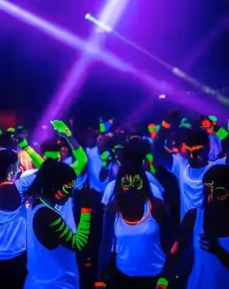 Cañones UV de alto output iluminando venue grande con luz negra