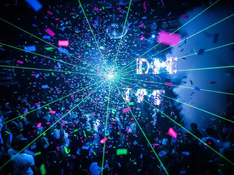 Confeti en discoteca con laser verde y bola de espejos