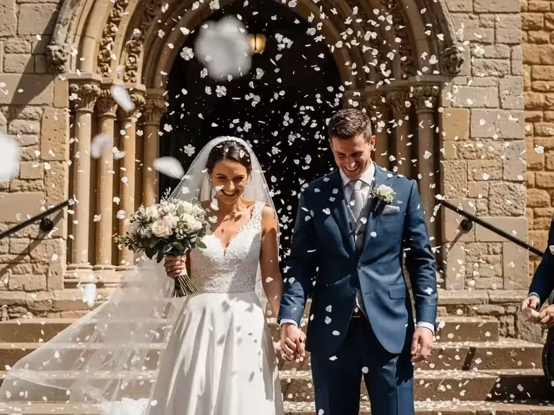 Confeti en la salida de la iglesia con novios felices