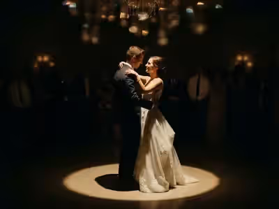 Círculo de luz blanco sobre los novios en un salón con candil encendido