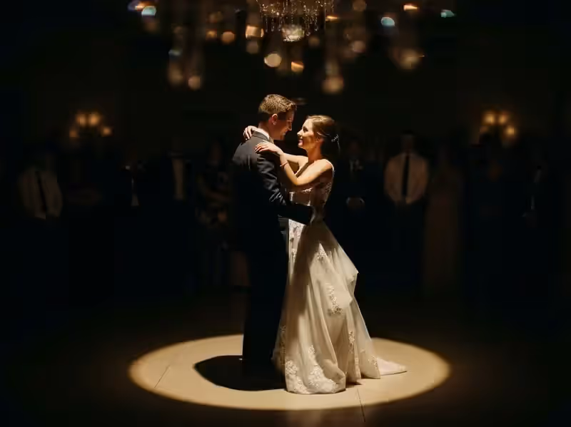 Seguidor de luz sobre novios bailando en salón con candiles