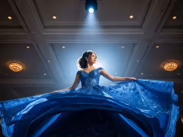 Quinceañera con tiara y vestido azul iluminada con seguidor