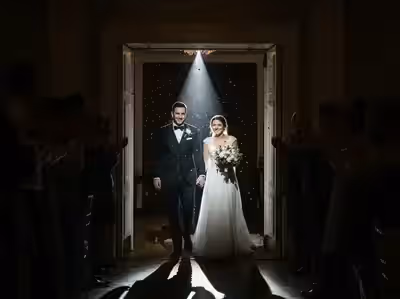 Entrada de los novios recibida con aplausos dentro del haz de luz