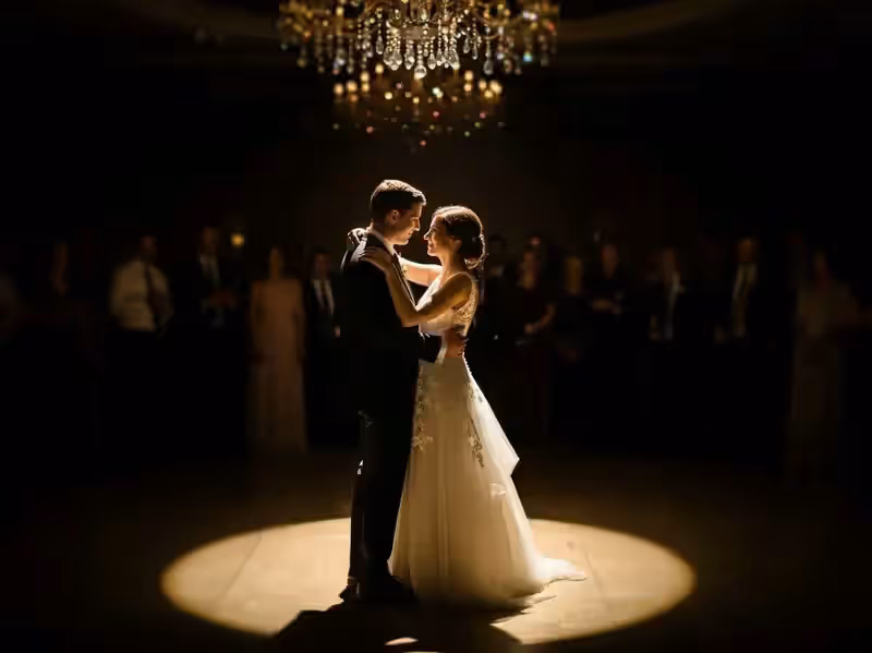 Vals de novios seguido por el haz cerrado del follow spot bajo un candil