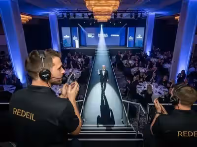 Dos seguidores cruzados sobre el escenario de una gala corporativa