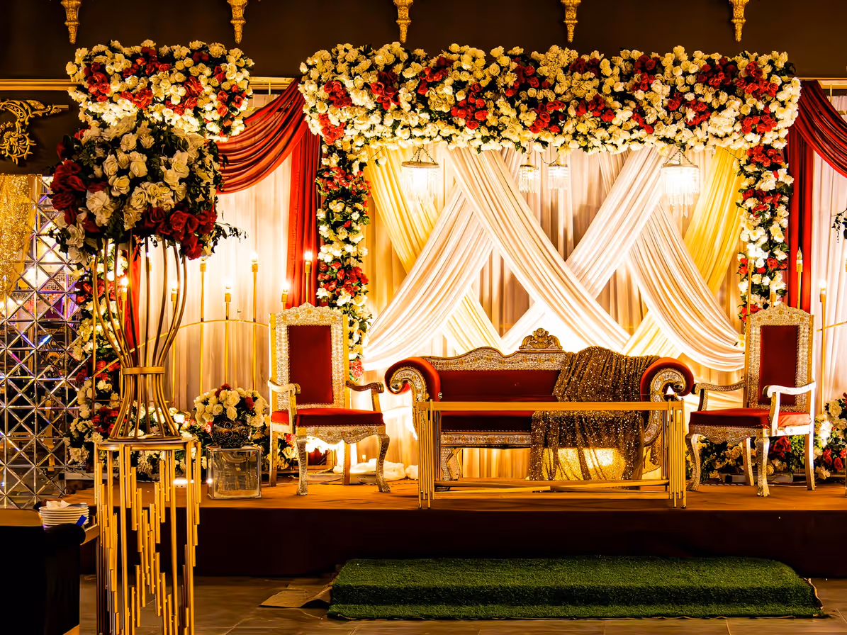 Escenario de boda con flores, cortinas y asientos