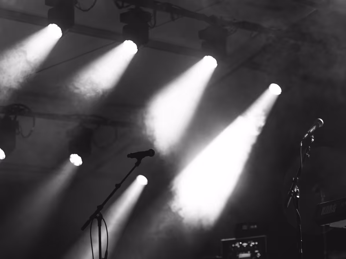 Escenario con micrófonos y luces en blanco y negro