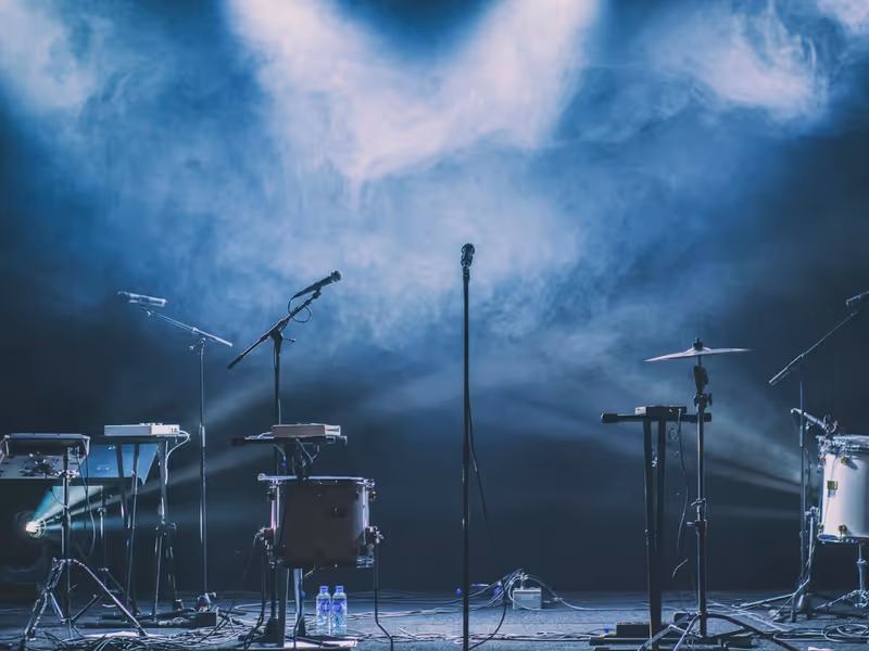 Instrumentos y micrófonos sobre escenario con luces azules