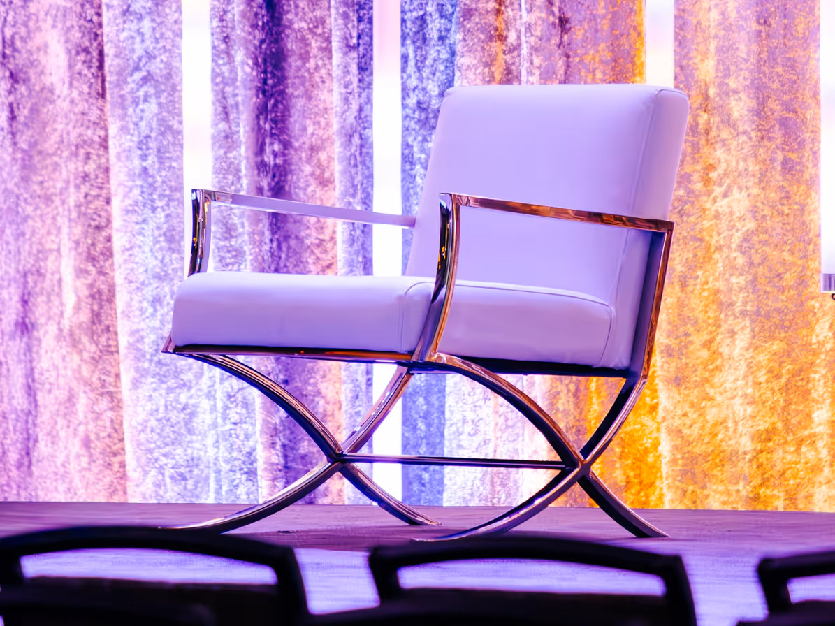 Silla blanca sobre escenario con iluminación de colores